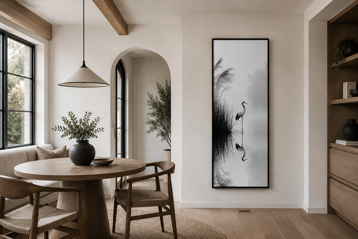 Tall narrow black and white Japanese crane wall art in a minimalist dining room with zen decor.
