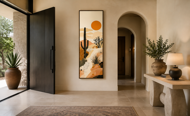 Tall narrow framed canvas wall art featuring a desert cactus and orange sun in an entryway.