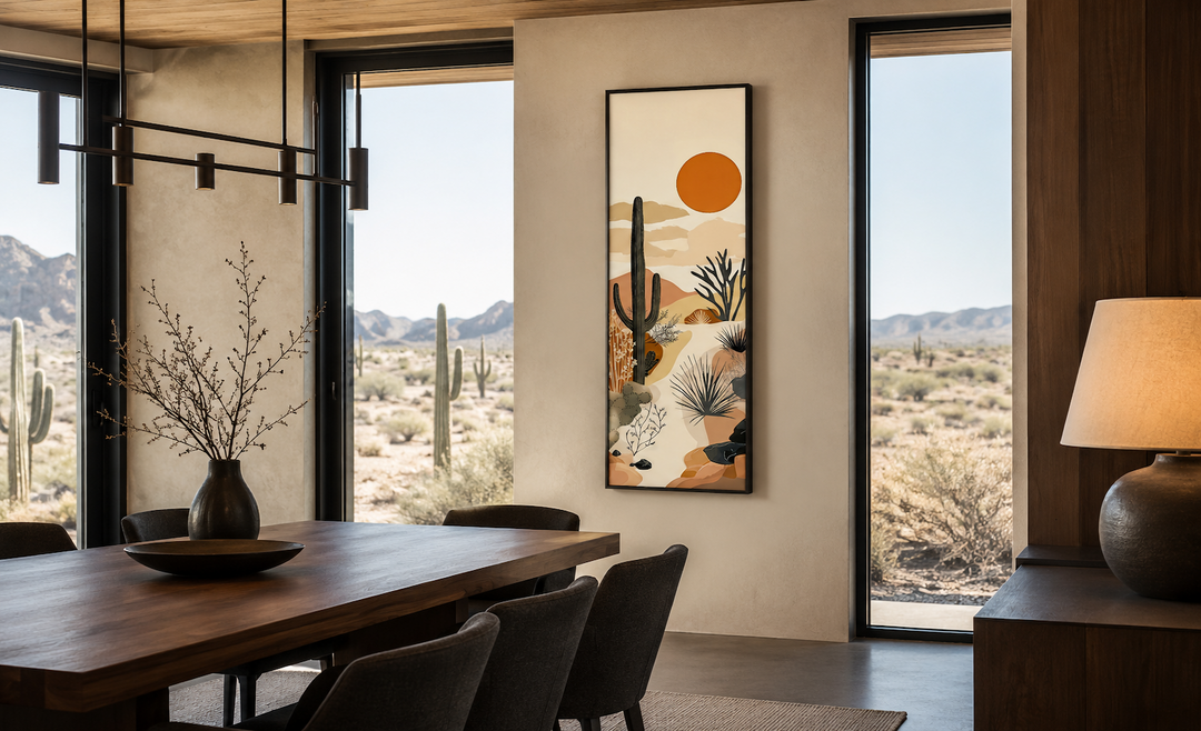 Tall narrow framed canvas art of a desert cactus and orange sun in a modern dining room.