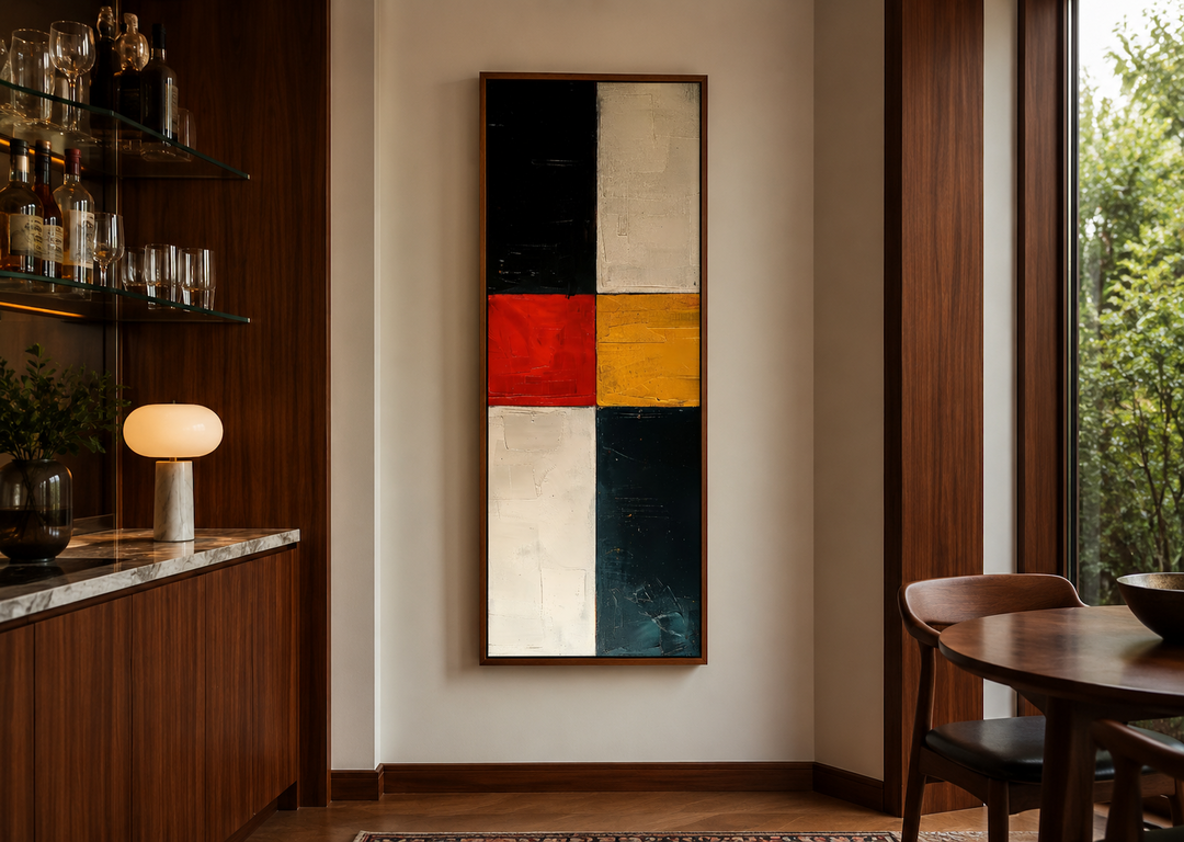 Tall narrow vertical wall art with geometric blocks of black, white, red, and yellow in a wood frame.