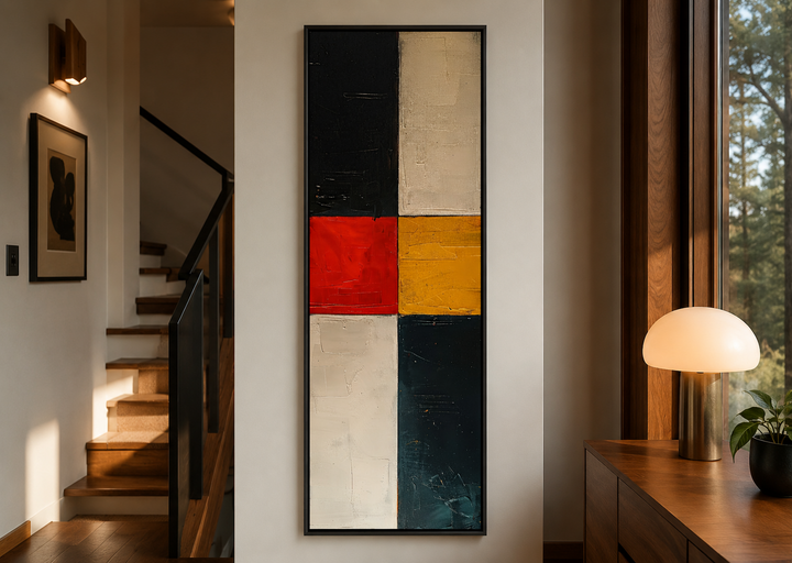 Tall narrow vertical wall art with a geometric black, white, red, and yellow abstract design.