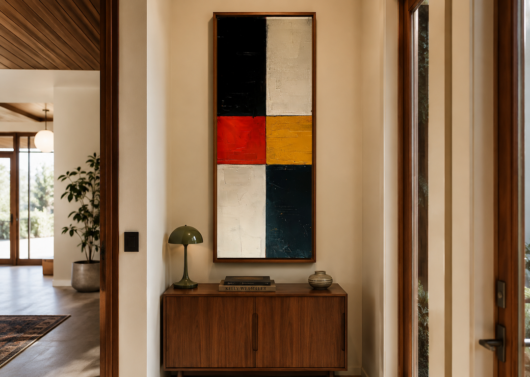 Tall narrow vertical wall art with geometric blocks of black, white, red, and yellow in a wood frame.
