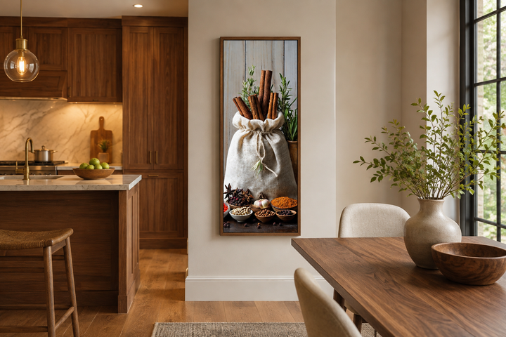 Tall narrow vertical framed canvas wall art featuring a sack of cinnamon sticks and various spices.
