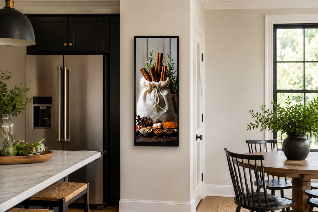 Tall narrow vertical framed canvas wall art of herbs and spices in a sack on a kitchen wall.