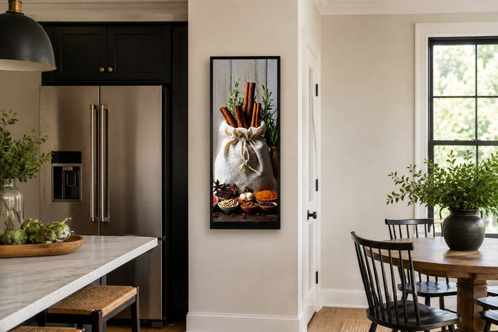 Tall narrow vertical framed canvas wall art of herbs and spices in a sack on a kitchen wall.