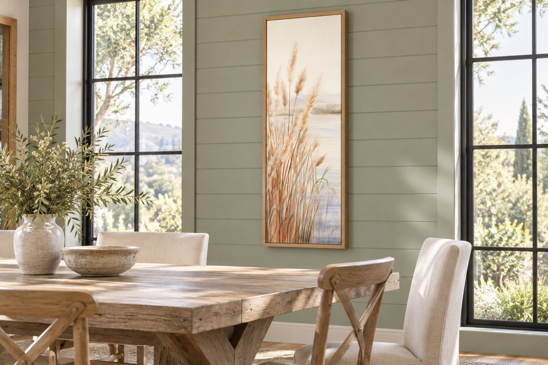 Vertical framed canvas wall art of pampas grass on a beach in a neutral-toned dining room.