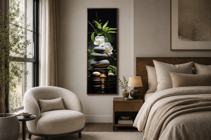 Tall narrow framed canvas art of stacked rocks, white orchids, and bamboo in a zen bedroom setting.