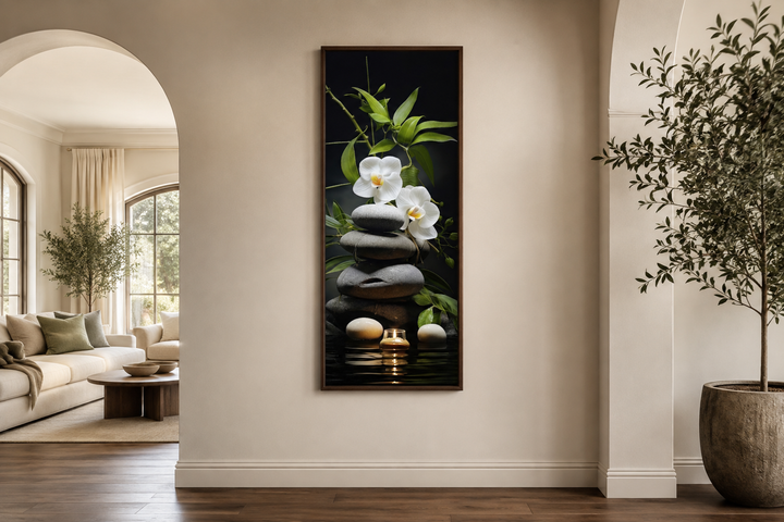 Tall narrow vertical canvas art of stacked rocks, white orchids, bamboo, and a candle on a wall.