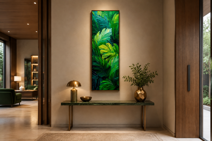 Vertical canvas print of lush green tropical leaves in a painterly style above a console table.