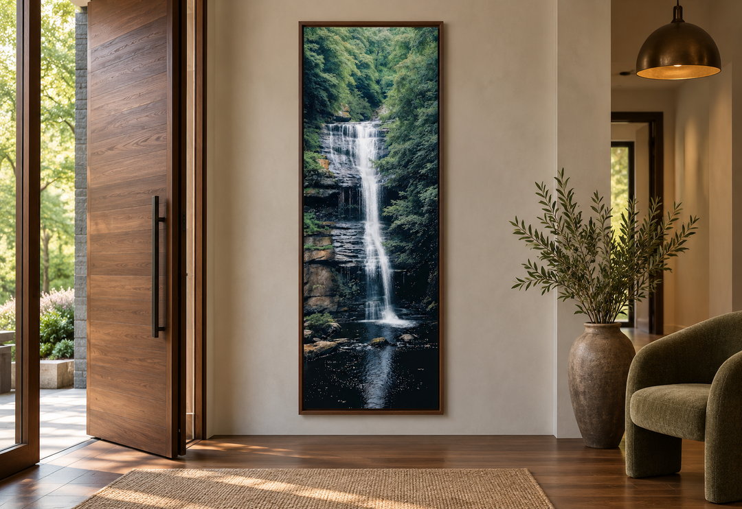 Tall narrow vertical framed canvas wall art featuring a serene waterfall in a lush green forest.