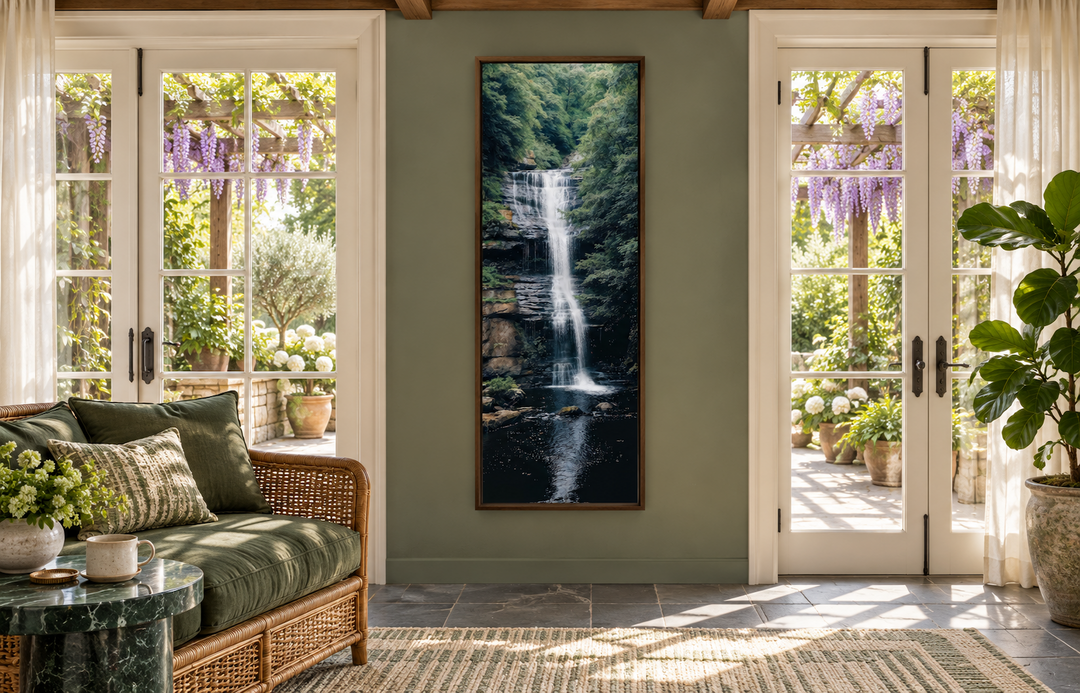 Tall narrow vertical framed canvas wall art featuring a serene waterfall in a lush green forest.