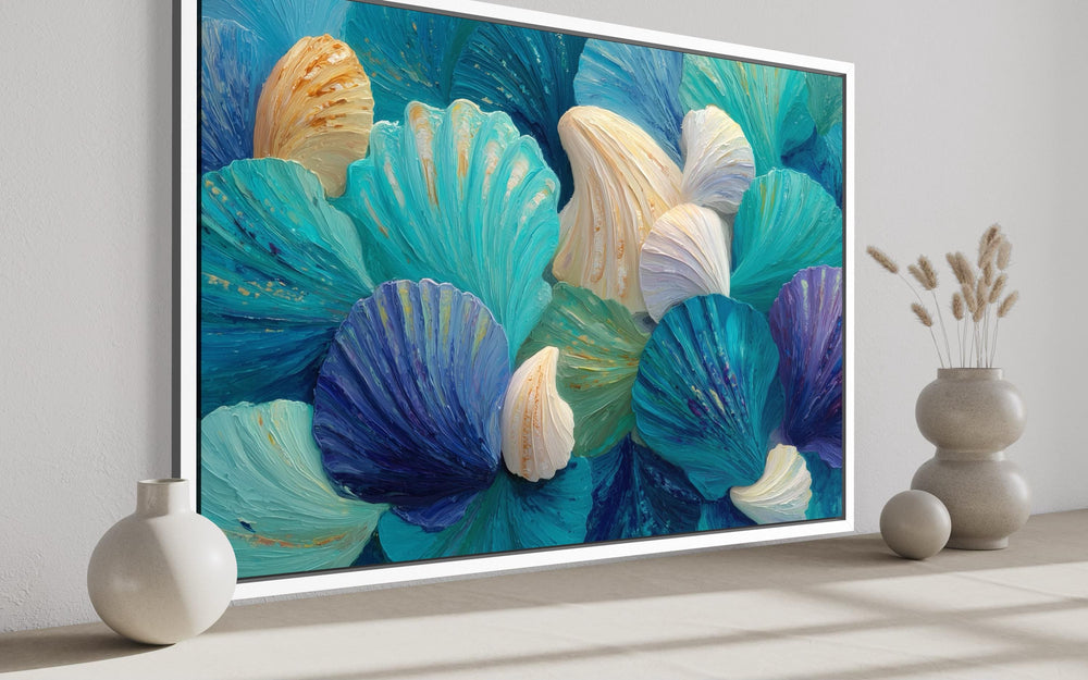 Textured abstract wall art of overlapping teal, aqua, and ivory seashells in a coastal room.