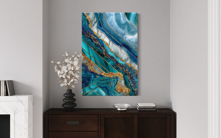 Teal and gold abstract marble framed canvas wall art hanging above a dark wood console table.