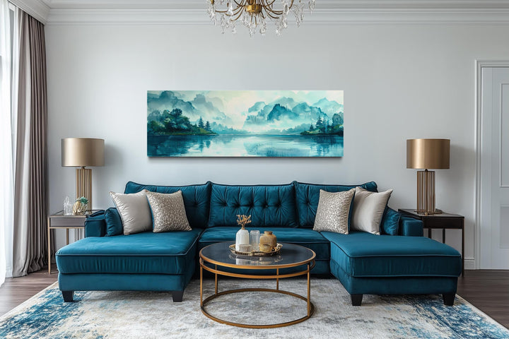 Teal mountain lake horizontal canvas wall art hanging above a blue velvet sectional sofa.