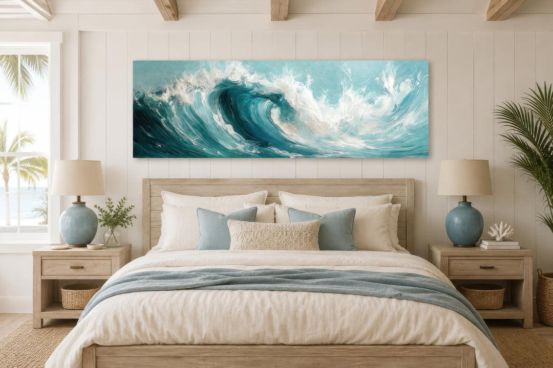 Teal ocean wave panoramic framed canvas wall art hanging over a bed in a coastal style bedroom.