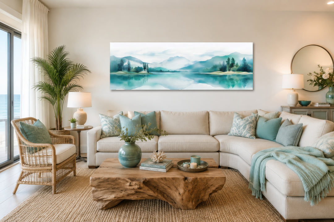 Teal watercolor mountain and lake landscape panoramic wall art displayed above a living room sofa.