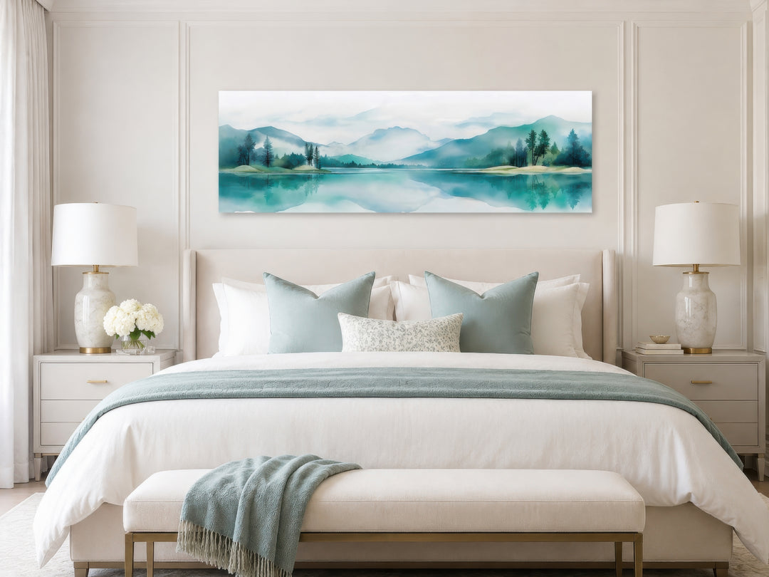 Teal watercolor mountain and lake landscape wall art in a long narrow format above a bed.