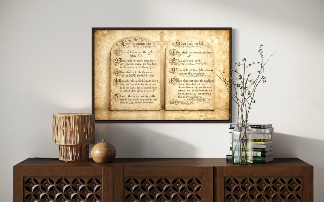 A framed canvas print of the Ten Commandments in antique script hangs above a wooden sideboard.