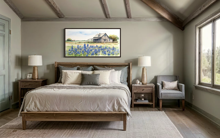 Texas barn wall art with bluebonnet field print canvas hanging above a wooden bed in a bedroom.