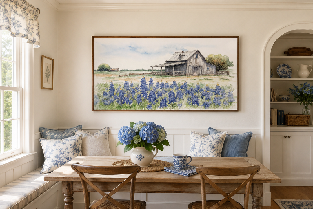 Framed horizontal canvas art of a rustic Texas barn in a field of bluebonnets over a dining area.