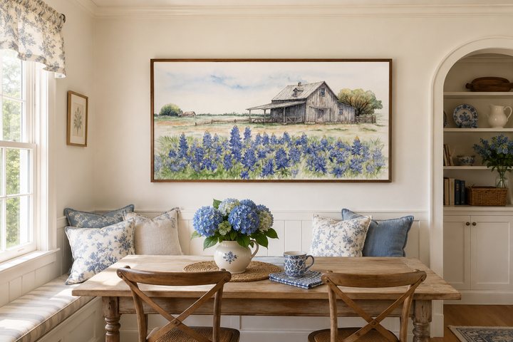 Framed horizontal canvas art of a rustic Texas barn in a field of bluebonnets over a dining area.