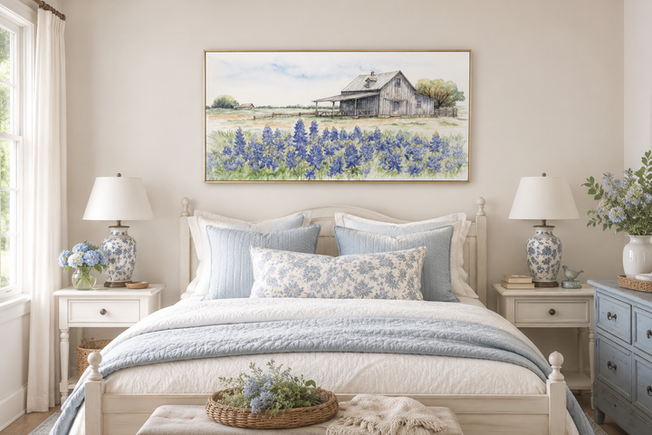 Horizontal canvas wall art of a rustic Texas barn in a field of bluebonnets above a bed.