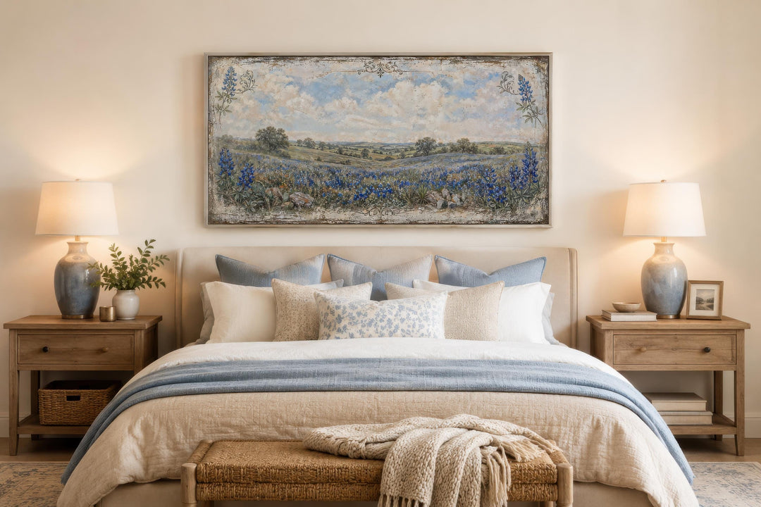 Texas Bluebonnet wall art above a bed with blue and cream pillows and matching bedside lamps.