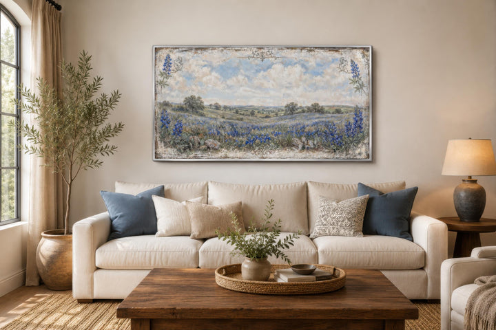 Vintage Texas bluebonnet landscape canvas print above a cream sofa in a neutral living room.