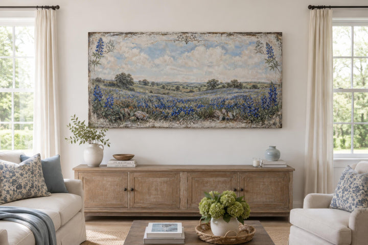 Vintage Texas bluebonnet landscape canvas print hanging above a wooden console in a bright room.