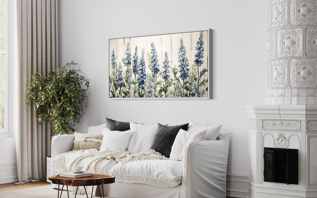 Texas Bluebonnets painted on wood rustic framed canvas wall art hanging above a white sofa.