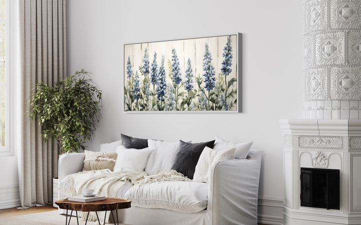 Texas Bluebonnets painted on wood rustic framed canvas wall art hanging above a white sofa.