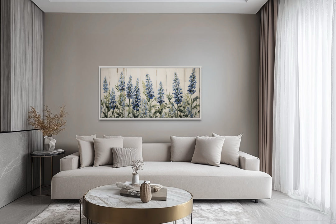 Texas Bluebonnets painted on wood rustic framed canvas wall art hanging above a modern beige sofa.