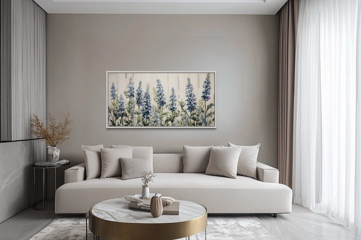 Texas Bluebonnets painted on wood rustic framed canvas wall art hanging above a modern beige sofa.