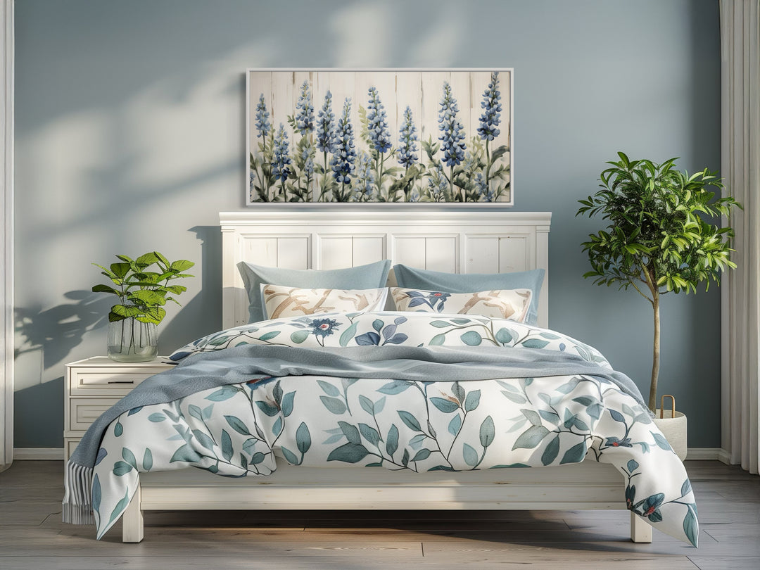 Texas Bluebonnets painted on wood rustic framed canvas wall art hanging above a white bed.
