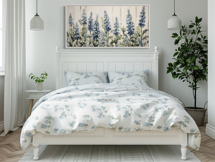 Texas Bluebonnets painted on wood rustic framed canvas wall art hanging above a white bed.
