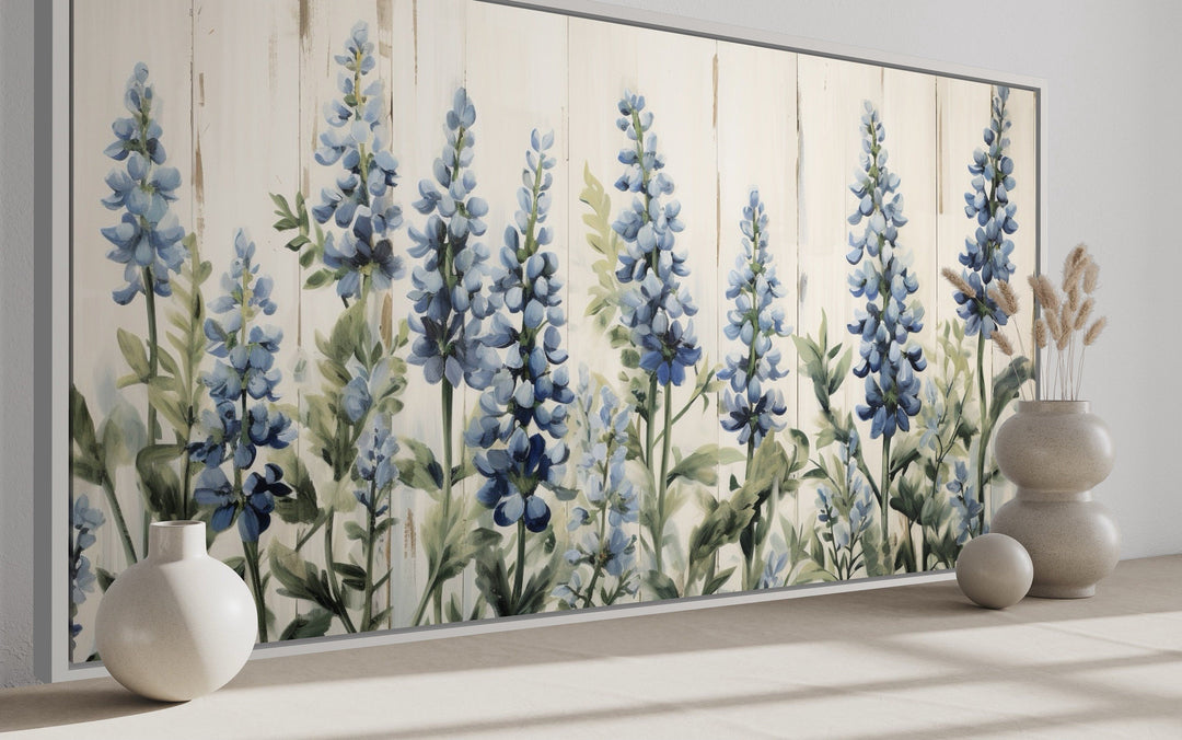 Rustic framed canvas wall art featuring bluebonnets painted on a light wood grain background.