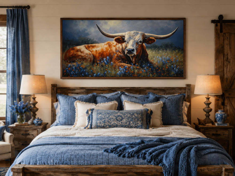 Framed canvas print of a Texas Longhorn lying in a bluebonnet field above a rustic wooden bed.