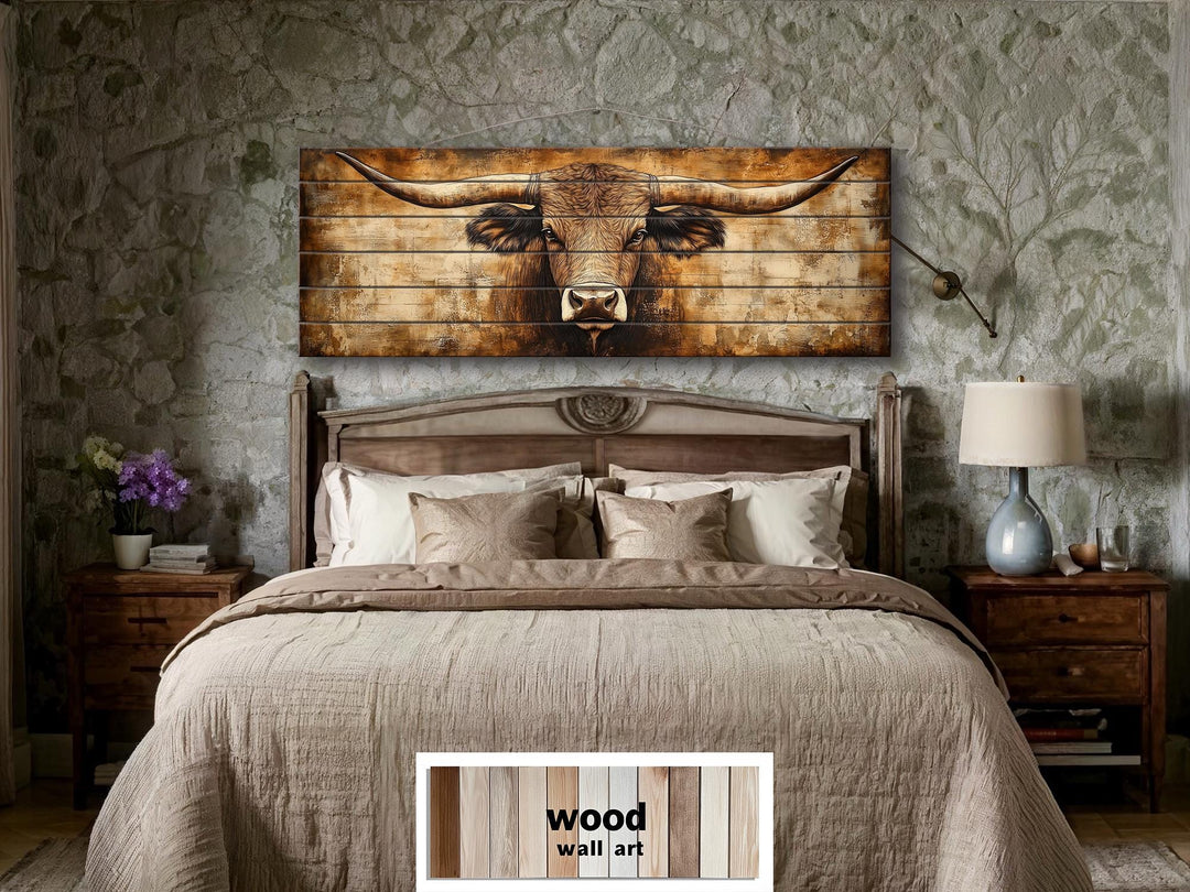 Texas longhorn horizontal wood wall art above a bed in a rustic room with stone walls.
