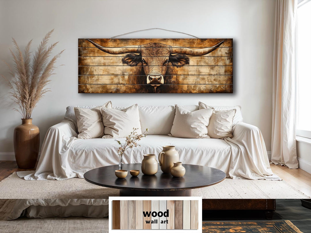 Texas longhorn printed on horizontal real wood planks, hanging above a white sofa in a rustic room.