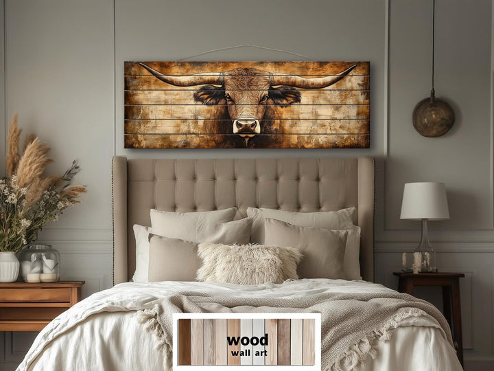 Texas longhorn horizontal wood wall art hanging above a tufted headboard in a neutral bedroom.