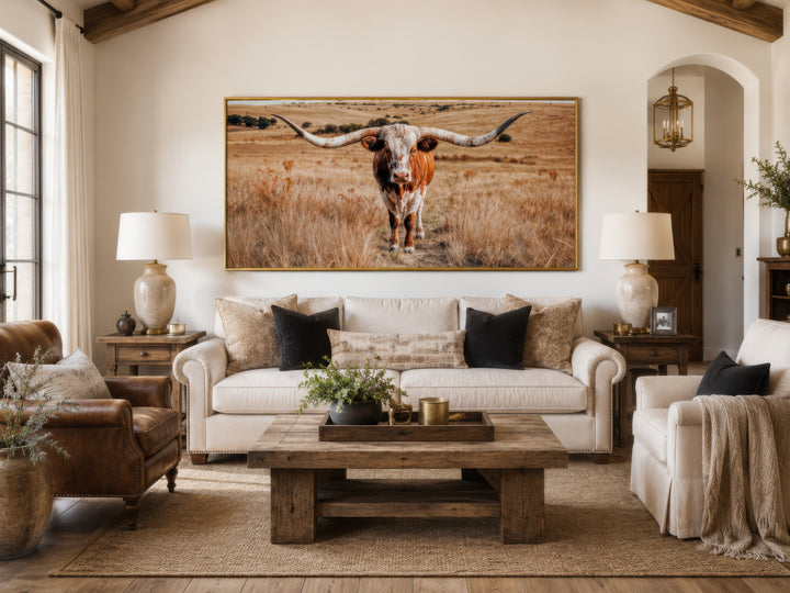 Texas Longhorn photography framed canvas wall art above a sofa in a rustic living room.