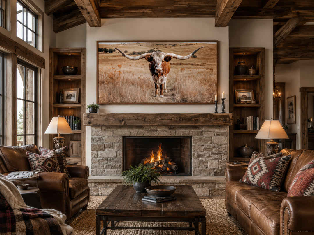 Texas Longhorn photography framed canvas wall art above a stone fireplace in a rustic living room.