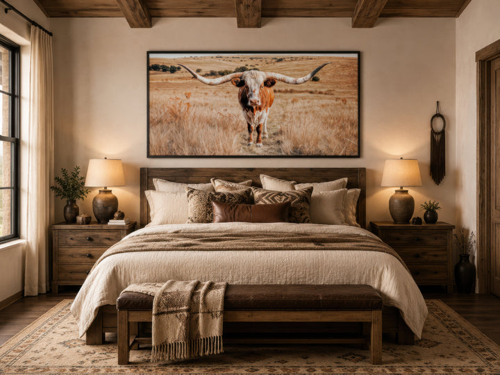 Texas Longhorn photography framed canvas wall art hanging above a bed in a rustic bedroom.