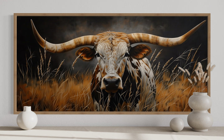 Framed canvas wall art of a Texas longhorn steer in a field of grass with a rustic farmhouse style.