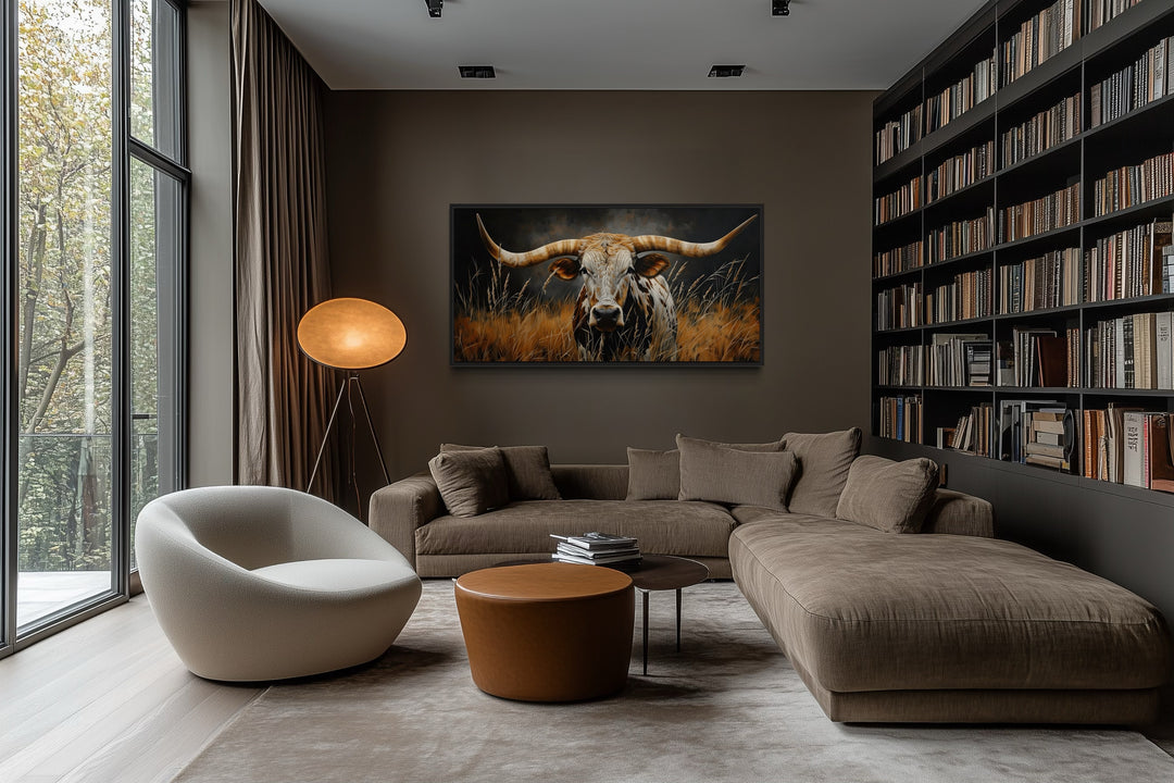 Framed canvas wall art of a Texas longhorn steer in grass, hung in a modern rustic living room.