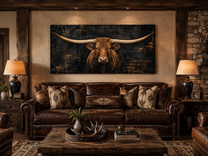 Texas Longhorn canvas wall art above a brown leather sofa in a rustic Western-style living room.