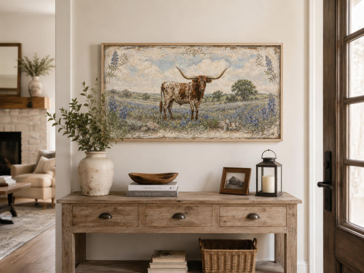 Texas Longhorn canvas wall art in a rustic frame above a wooden console table with farmhouse decor.