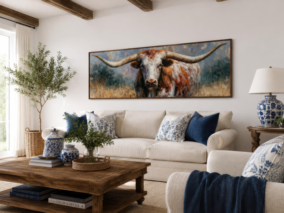Texas Longhorn wall art in a long narrow frame above a white sofa in a farmhouse living room.