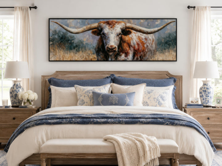 Long narrow canvas print of a Texas Longhorn bull hanging above a bed in a farmhouse bedroom.