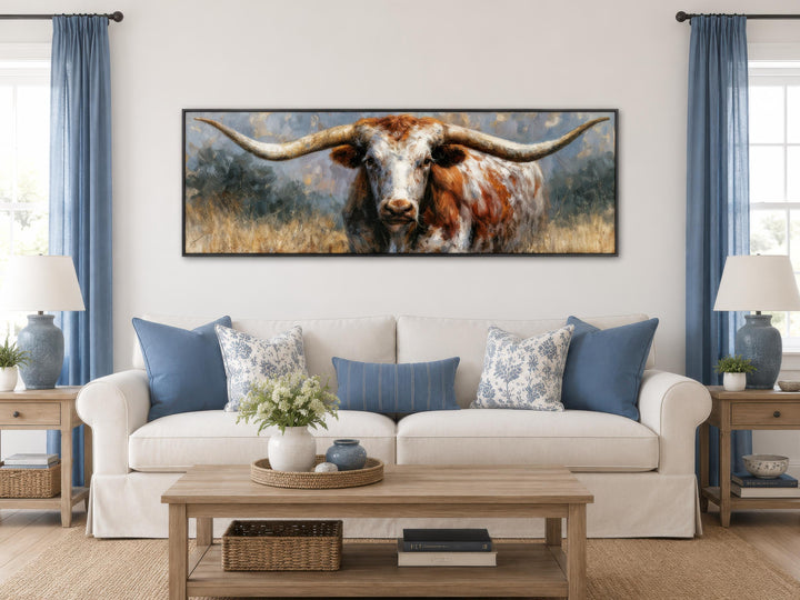 Texas Longhorn bull canvas print in a long narrow frame above a white sofa in a farmhouse living room